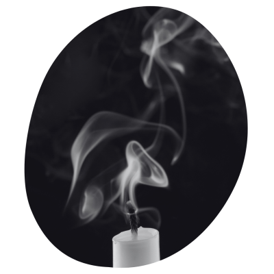 A white taper candles with smoking bellowing from the blown out wick